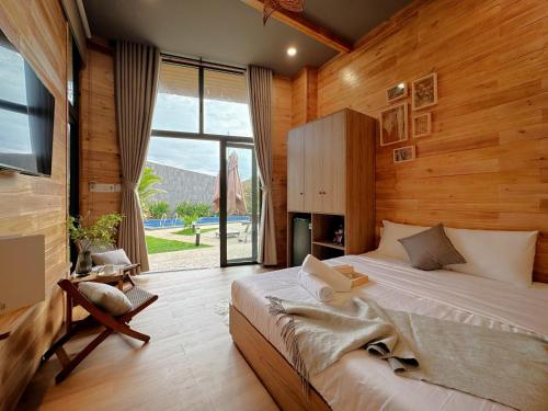 a bedroom with a large bed and a large window at Vanilla Ho Tram Homestay in Ho Tram