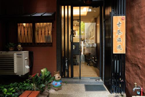 a door to a building with a teddy bear standing outside at 赤樓古巷民宿 6-12人可包棟 in Tainan