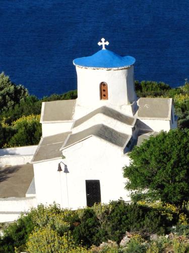 a small white church with a blue roof at Velanidia Homestay in Velanídhia