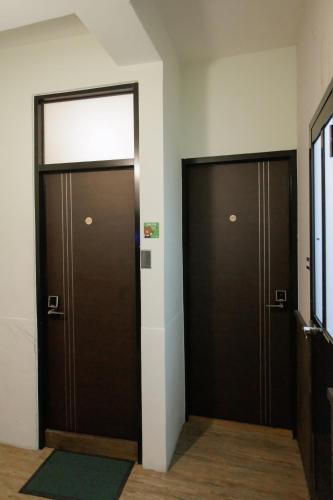 two brown doors in a hallway with a rug at 赤樓古巷民宿 6-12人可包棟 in Tainan