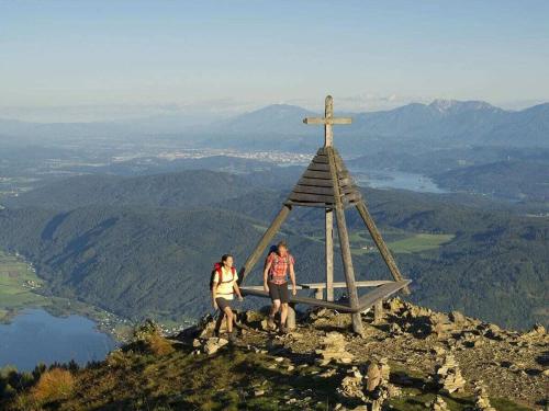two people standing on top of a cross on a mountain at Holiday home in Faak am See in Faak am See