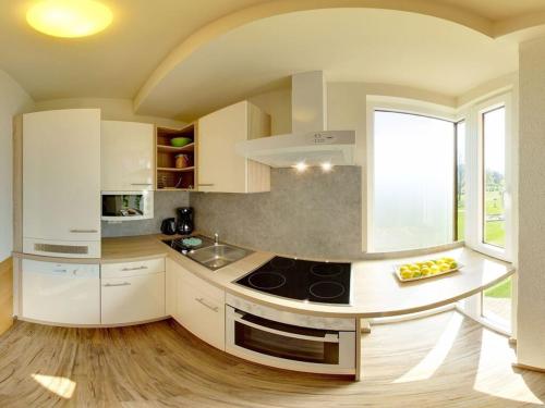 a kitchen with white cabinets and a stove top oven at Holiday home in Faak am See in Faak am See