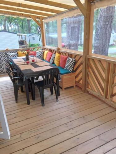 une véranda avec une table et un canapé dans l'établissement Mobilhome au bord de mer, à Piriac-sur-Mer