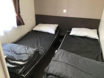 Cette petite chambre dispose de 2 lits superposés et d'une fenêtre. dans l'établissement Mobilhome au bord de mer, à Piriac-sur-Mer