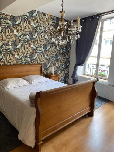 sypialnia z łóżkiem i żyrandolem w obiekcie La Chambre d'Angèle w mieście Sedan