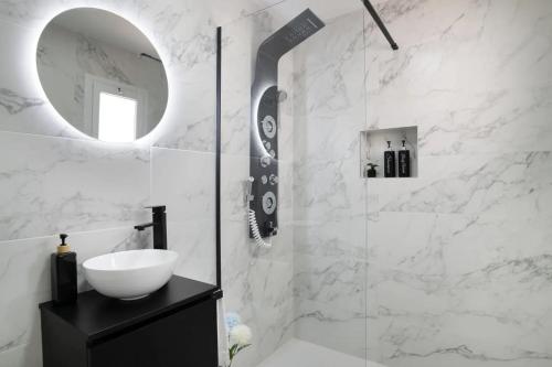 een witte badkamer met een wastafel en een spiegel bij Loft Marina in Vejer de la Frontera