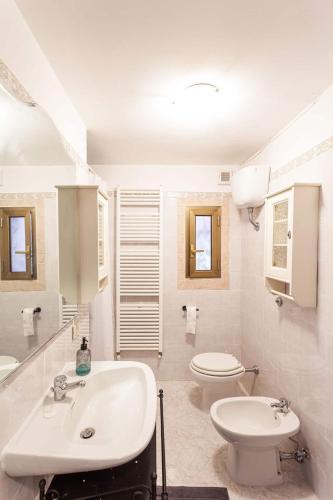 a white bathroom with a sink and a toilet at Casetta nel bosco di Valeria e Davide in Rocca Priora