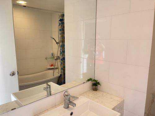 a bathroom with a sink and a mirror and a tub at Milford paradise in Pran Buri