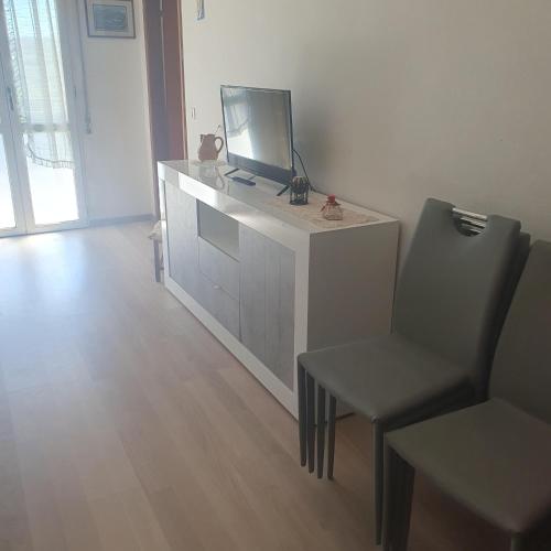 a living room with a tv and a chair at Discover Appennino - Via Roma 72, 4 - Montecreto in Montecreto