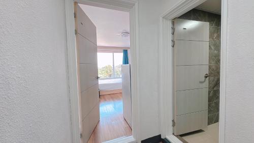 a hallway with a door to a room with a window at Garden in Jeju 201 in Seogwipo