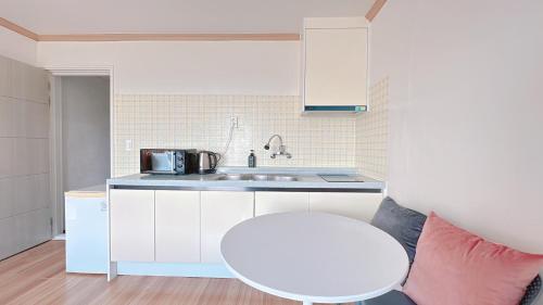 a kitchen with a white table and a sink at Garden in Jeju 201 in Seogwipo