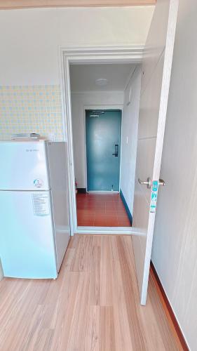 an empty hallway with a refrigerator in a room at Garden in Jeju 201 in Seogwipo
