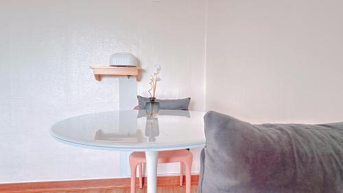 a white table with a vase on it next to a couch at Garden in Jeju 201 in Seogwipo