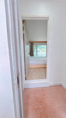 a hallway with a mirror and a bed in a room at Garden in Jeju 201 in Seogwipo