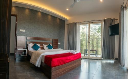 ein Schlafzimmer mit einem großen Bett und einem großen Fenster in der Unterkunft Udaya Hills Cottages in Vagamon