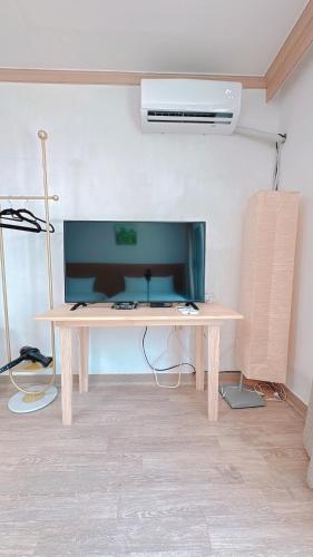 a wooden desk in a room with a fan at Garden in Jeju 201 in Seogwipo