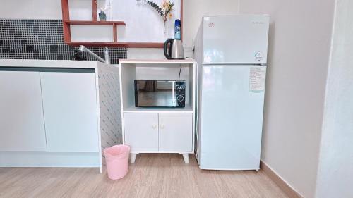 a kitchen with a white refrigerator and a microwave at Garden in Jeju 201 in Seogwipo