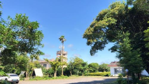 a house with a clock tower in the middle of a road at Garden in Jeju 201 in Seogwipo