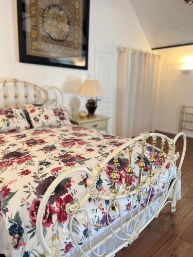 a bedroom with a bed with a floral bedspread at Chez Thomas 7 Route du Monde Ancien in Saint-Georges-dʼAunay