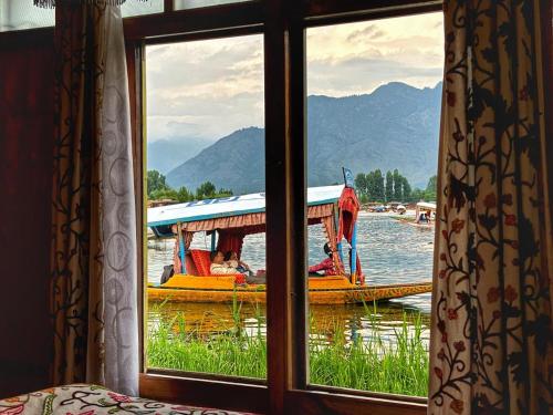 a window with a view of a boat in the water at White House Group Of Houseboats in Srinagar