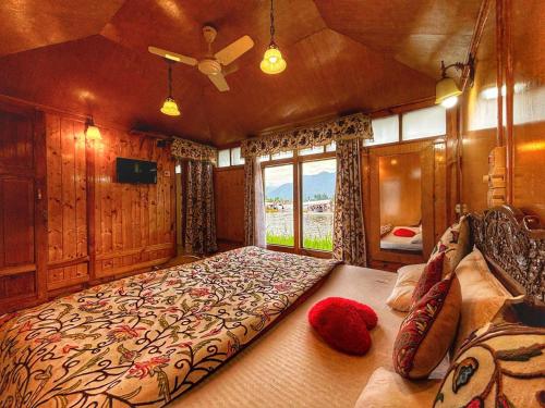 a bedroom with a large bed and a window at White House Group Of Houseboats in Srinagar