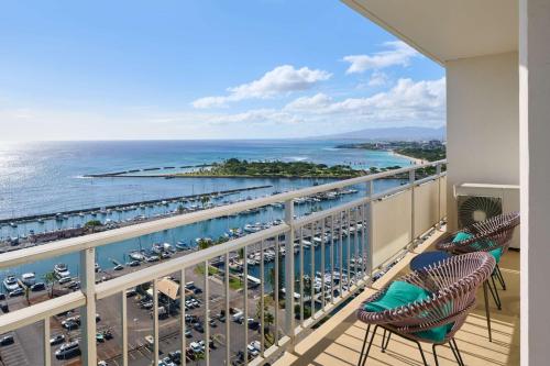 a balcony with chairs and a view of the ocean at Ilikai Hotel & Luxury Suites in Honolulu