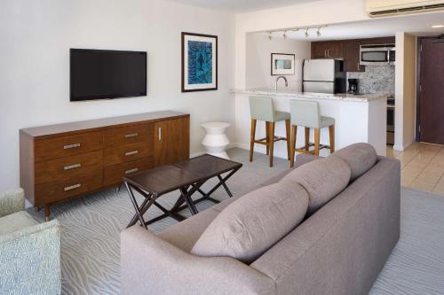 a living room with a couch and a kitchen at Ilikai Hotel & Luxury Suites in Honolulu
