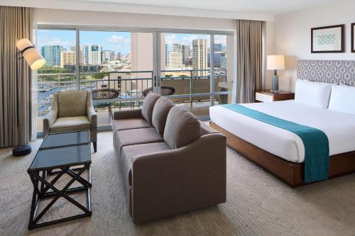 a hotel room with a bed and a couch at Ilikai Hotel & Luxury Suites in Honolulu