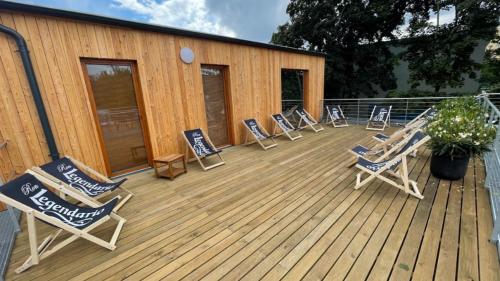 a deck with lounge chairs and a building at Tetris domky v Beachklubu Ládví in Prague