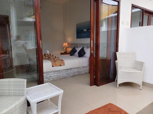 a bedroom with a bed and a table and chairs at Mahi Mahi House in Nusa Lembongan