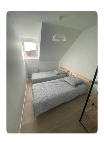 - une chambre avec 2 lits et une petite fenêtre dans l'établissement Appartement 2 pièces cosy proche centre ville, à Mulhouse