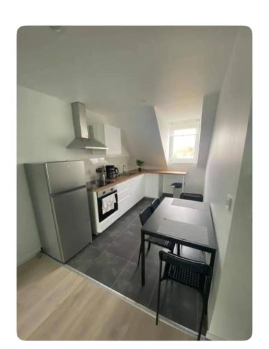une petite cuisine avec une table et un réfrigérateur dans l'établissement Appartement 2 pièces cosy proche centre ville, à Mulhouse