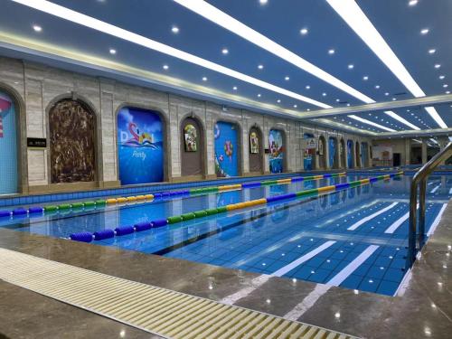 a swimming pool with colorful lanes in a building at Pullman Beijing South in Daxing