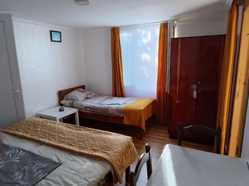 a small room with two beds and a table at Guesthouse Mery in K'obulet'i