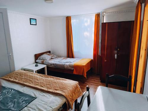 a small room with two beds and a table at Guesthouse Mery in K'obulet'i