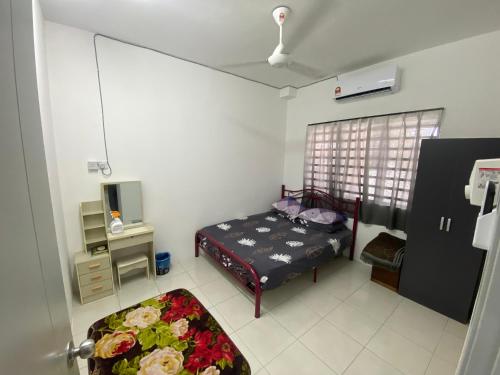 a small bedroom with a bed and a window at Azman Homestay in Batu Gajah