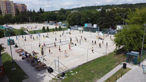 a group of people standing around a tennis court at Tetris domky v Beachklubu Ládví in Prague