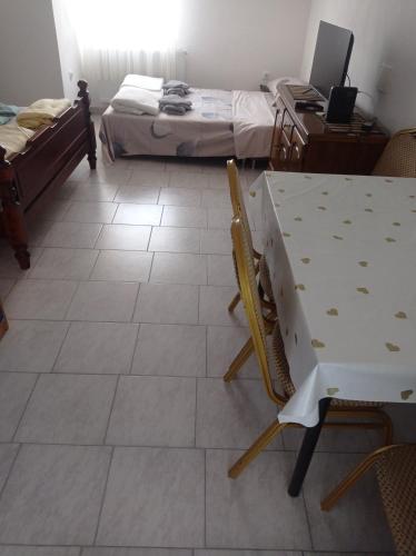 a room with a table and a desk and two beds at PAR in Donje Mladice