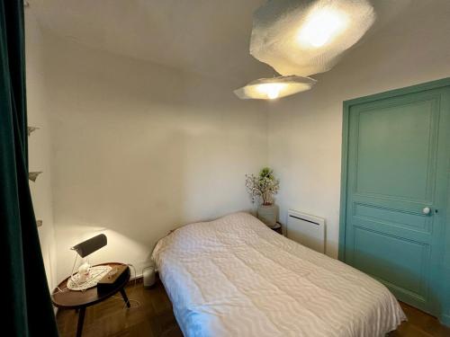 une chambre avec un lit et une table avec une lampe dans l'établissement Maison de village a la Turbie, à La Turbie