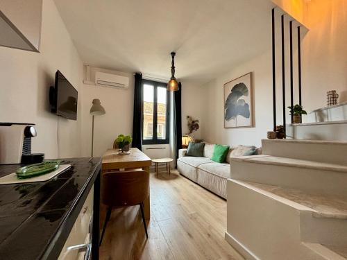 une cuisine et un salon avec un canapé dans une pièce dans l'établissement Maison de village a la Turbie, à La Turbie