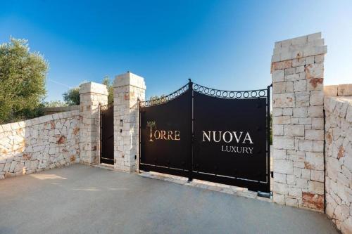 een poort naar een villa met een stenen muur bij WePuglia - Torre Nuova Luxury in Castellana Grotte