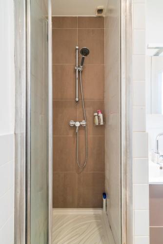une douche avec pommeau de douche dans une salle de bain dans l'établissement Apart Merryland Paris Châtelet, à Paris