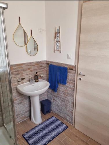 a bathroom with a sink and a mirror and a shower at Onda blu in Carini