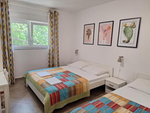 ein Schlafzimmer mit zwei Betten und einem Fenster in der Unterkunft Villa HAUS NIKO in Senj