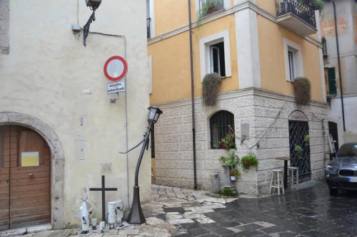 a building with a street sign next to a cross at Casa Edera in Isola del Liri