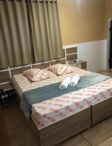 a bedroom with a bed with two slippers on it at Hotel itaquera Inn in Sao Paulo