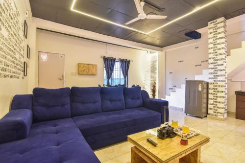 a living room with a blue couch and a table at Black Stone Villa in Lonavala