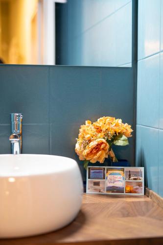 a bathroom with a sink and a vase of flowers at LOGGIA delle MERCANZIE in Brescia