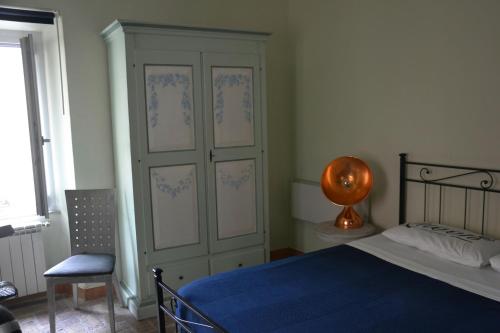 a bedroom with a bed and a cabinet and a chair at Casa Edera in Isola del Liri