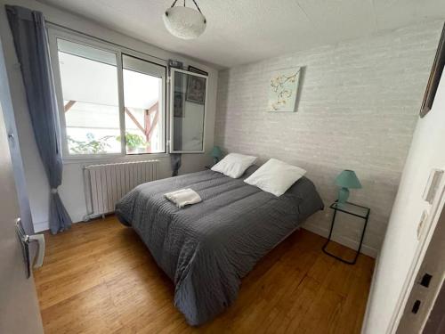 une chambre avec un lit et une grande fenêtre dans l'établissement Maison Bellevue, à Fumel